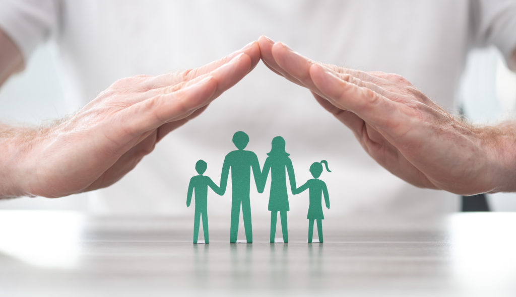 Family protected by hands - Concept of life insurance